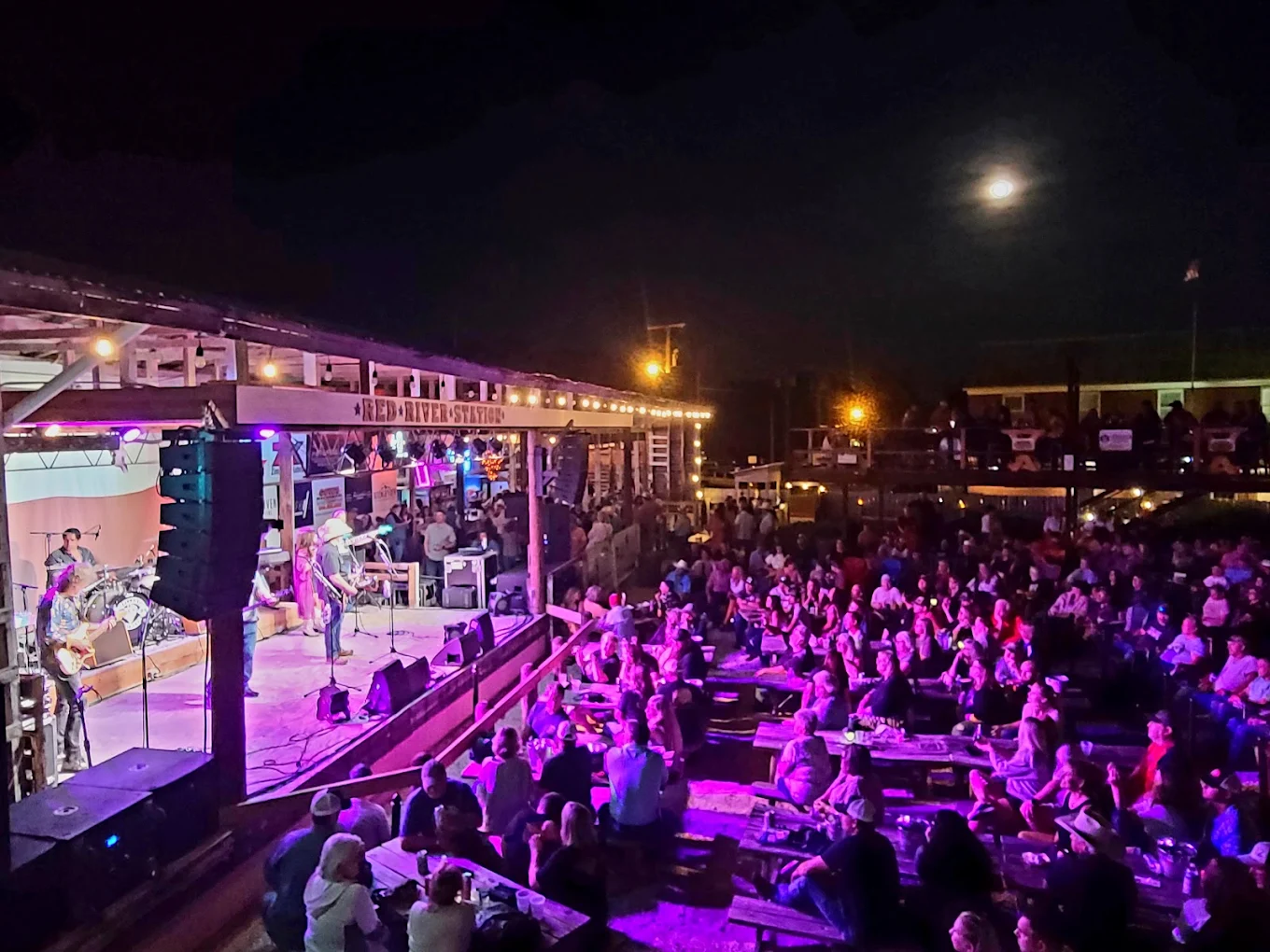 Packed crowd at the outdoor amphitheater under a full moon