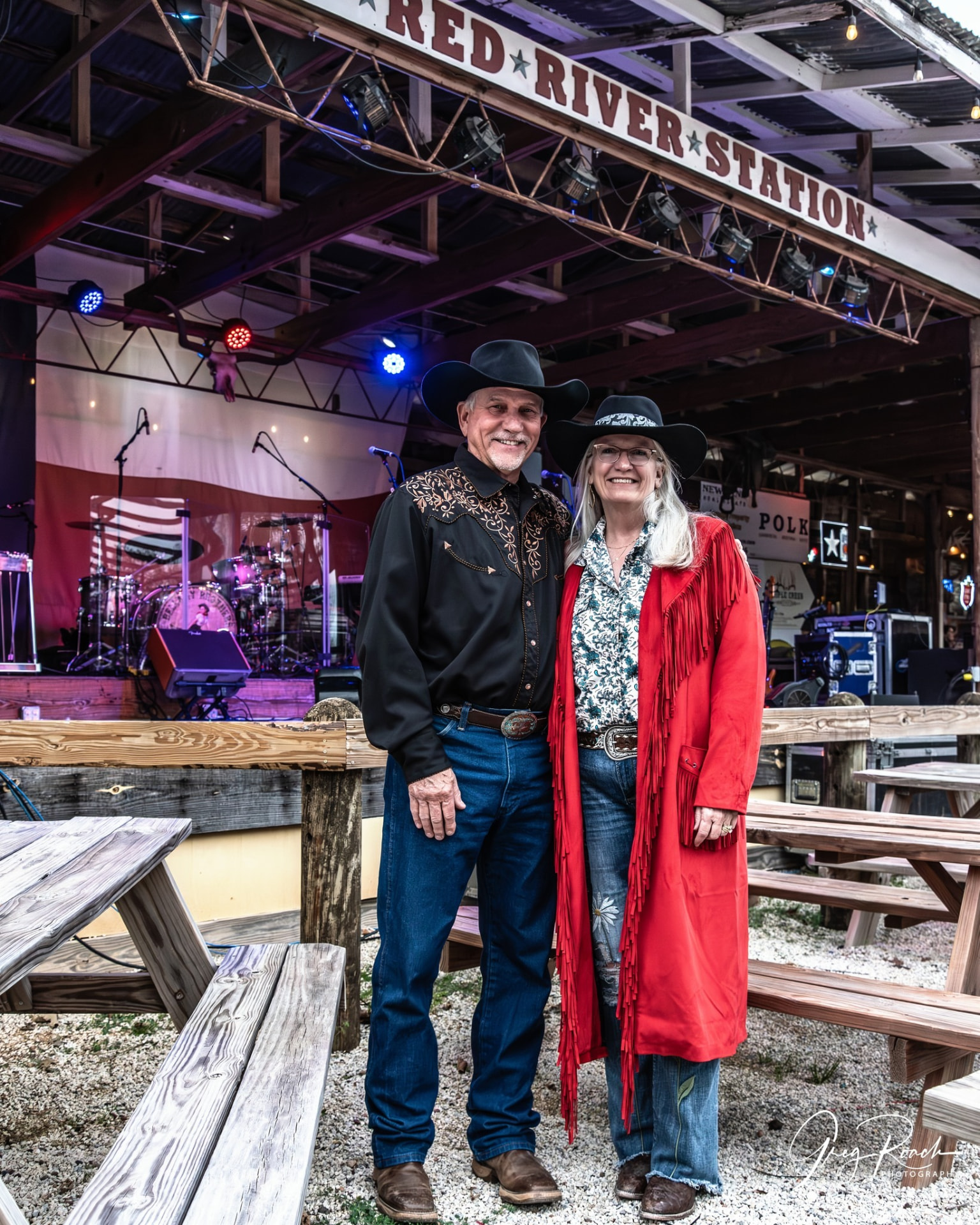 Curtis and Kathryn Goff in front of the Red River Station stage — owners of Red River Station